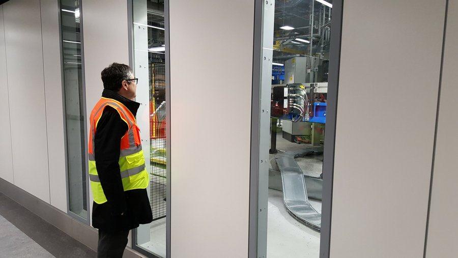 Man looking through window at automated baggage system