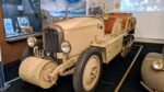 An open top, four seat half-track car painted in desert brown