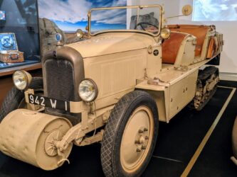 An open top, four seat half-track car painted in desert brown