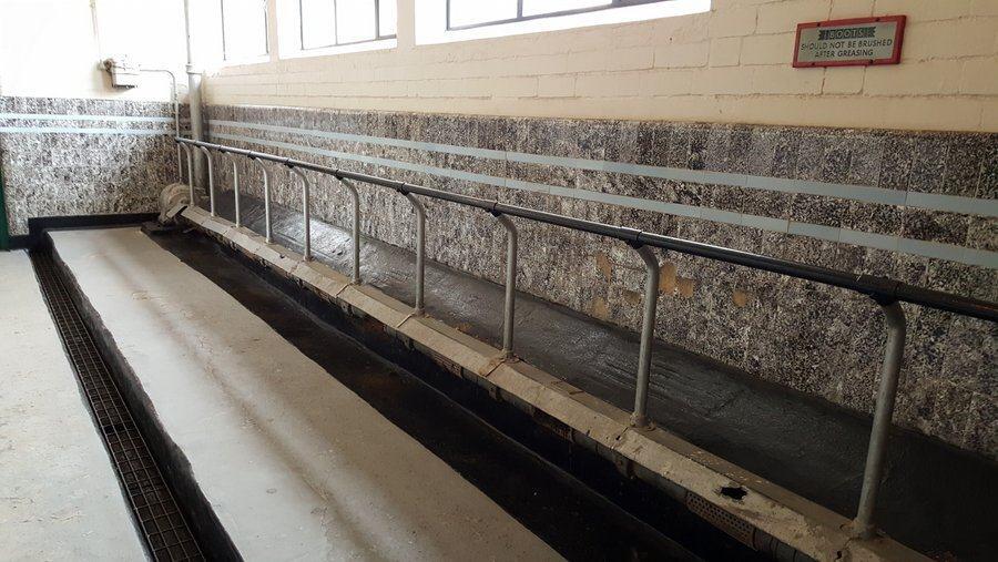 Room with a long trough and railing for washing mud of boots