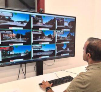 A man watches a monitor with nine video feeds on it