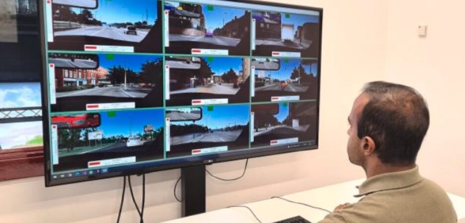 A man watches a monitor with nine video feeds on it