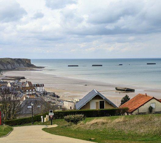 View looking down on the town of Arromanches, its beach, and Phoenix caissons out to sea