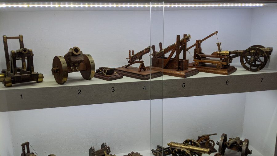 White shelves with models of bronze artillery and seige weapons