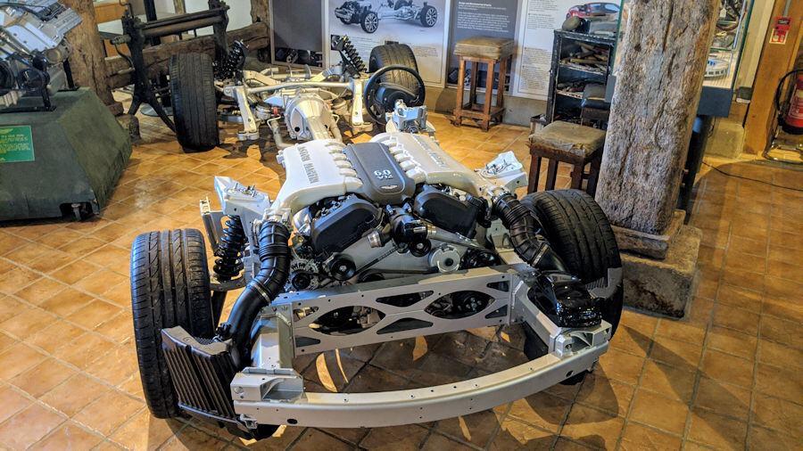 A silver engine and chassis on wheels for the Aston Martin Rapide