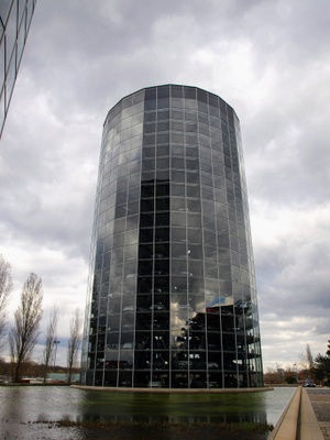 A glass tower filled with cars, on a grey cloudy day