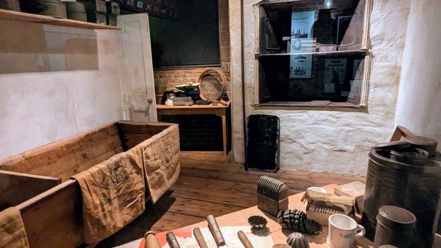 Bakery back room with boxes for flour, work benches, and cake and pie moulds