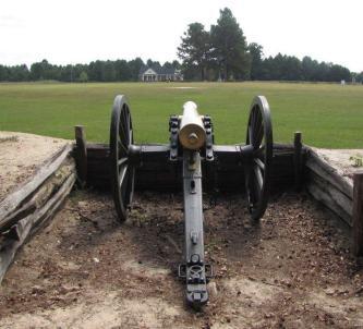 Cannon in an earthwork entrenchment at Bentonville, looking across a green field