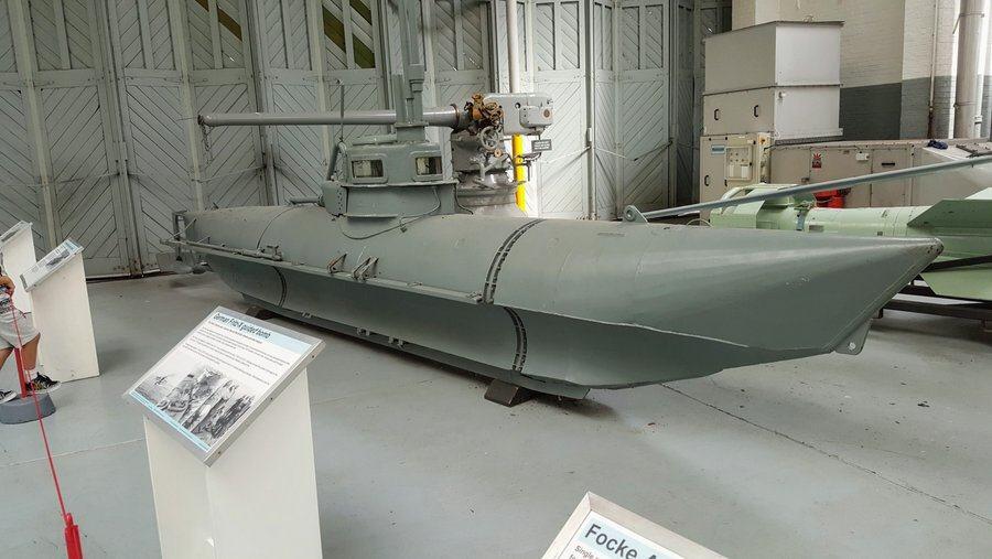 Small grey submarine exhibited in a hanger at IWM Duxford