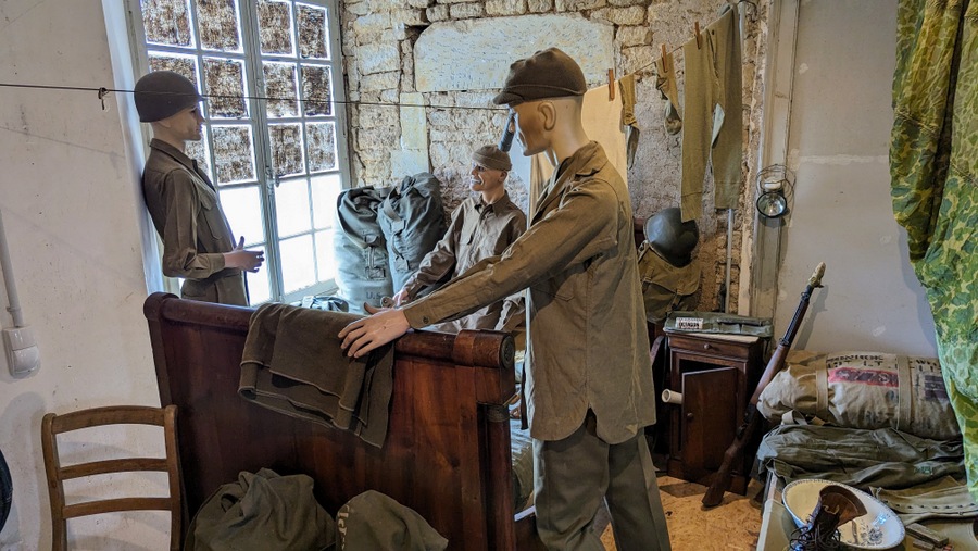 Soldiers (mannequins) stand by their camp beds and personal equipment