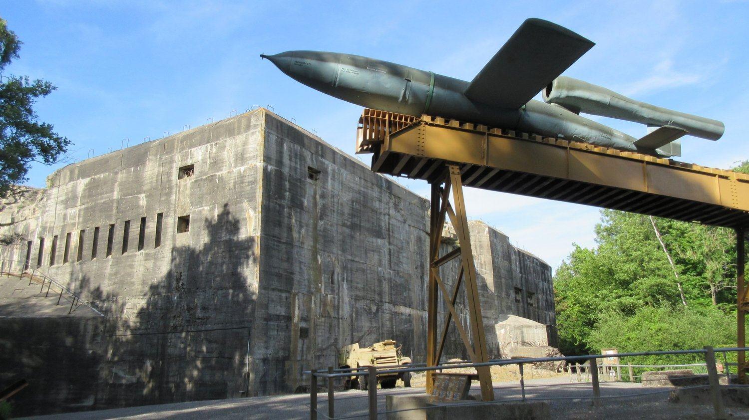 A V1 Flying Bomb on its launch ramp in the foreground with the massive blockhaus in the background