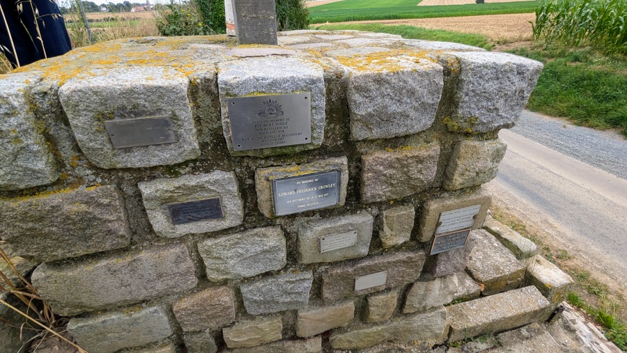 Little memorial plaques placed on individual bricks in the memorial face.