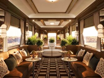 A design rendition of the observation carriage with luxurious furniture, dark wood panelling, and wrap-around windows at the back