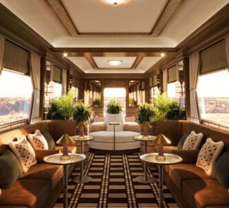 A design rendition of the observation carriage with luxurious furniture, dark wood panelling, and wrap-around windows at the back