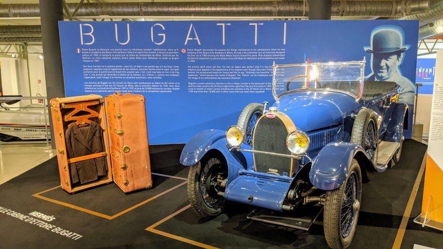 A blue Bugatti car and leather trunk displayed at the 24hr Le Mans Museum