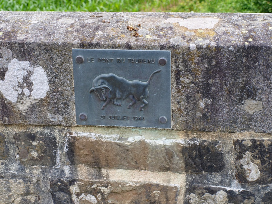 A small metal plaque with a bull emblem on the bridge parapet