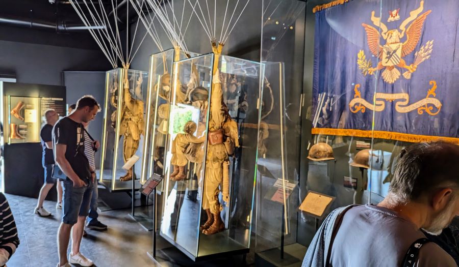 Visitors look at mannequins of paratroopers
