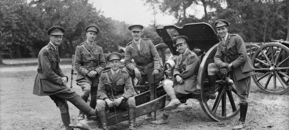 B/W image of six officers lounging on a field gun