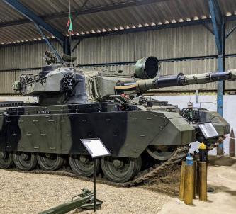 Large, green-camouflaged British main battle tank on display at the Norwich Tank Museum.
