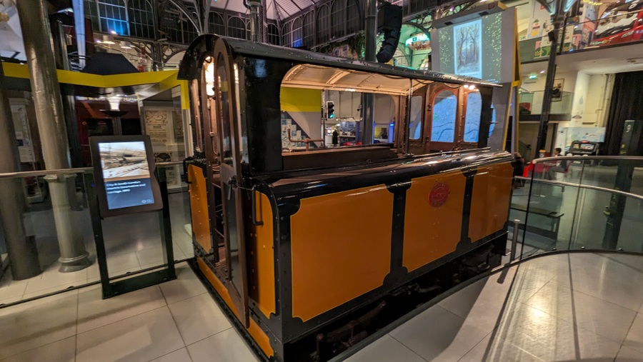 A small box-like locomotive with yellow sides and a glass-windowed cab.