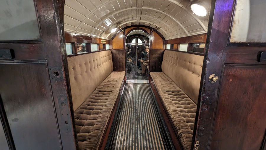 Coach interior with long velvet benches along the length and narrow windows above