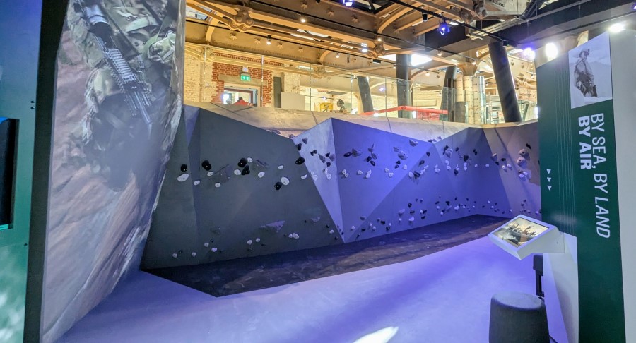 A small climbing wall. Above it workmen are working
