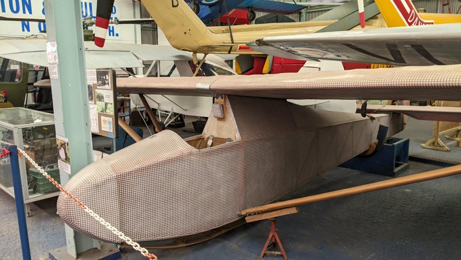 A small wooden glider covered in pink fabric