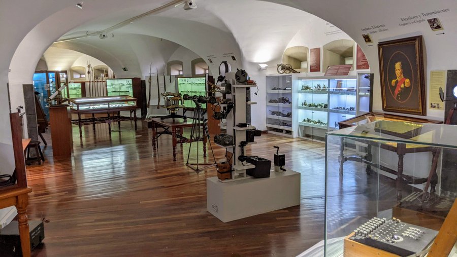 A vaulted white-walled gallery with display cases