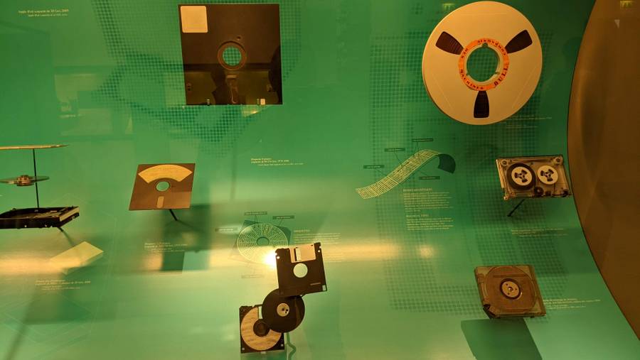 A display cabinet with old floppy disks, reel-to-reel tape, mini-discs, etc