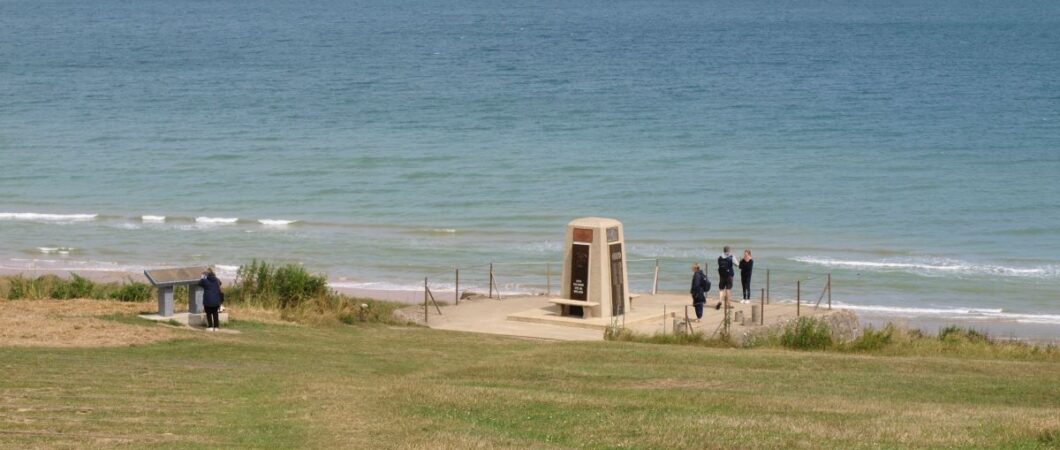 View of people around a D-Day memorial at Omaha beach