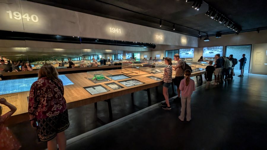 A dark gallery with long desk-like display cabinets