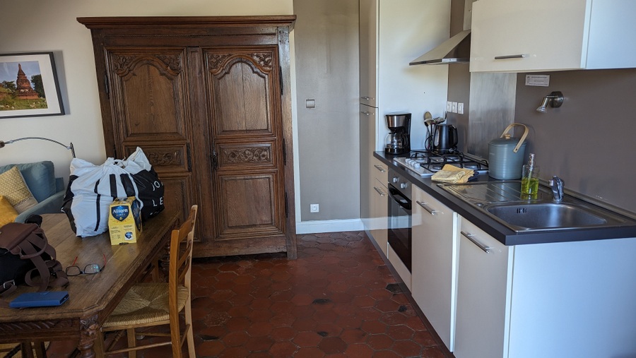 Kitchen area with a tiled floor and antique wooden cupboard