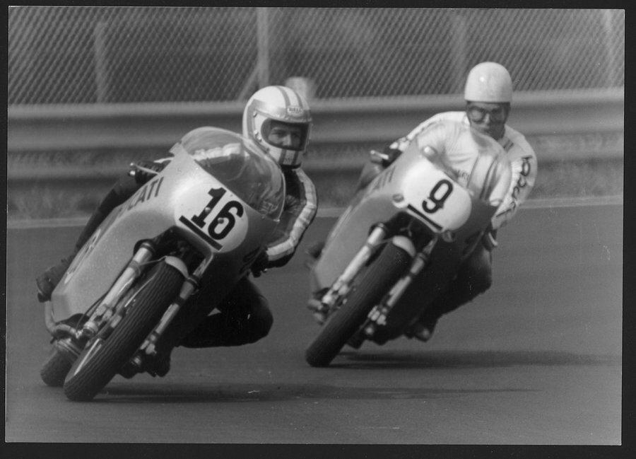 Black & white photo from the Ducati Museum of the race leaders leaning into a corner