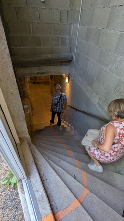 Visitors walk down steep steps into the underground bunker entrance