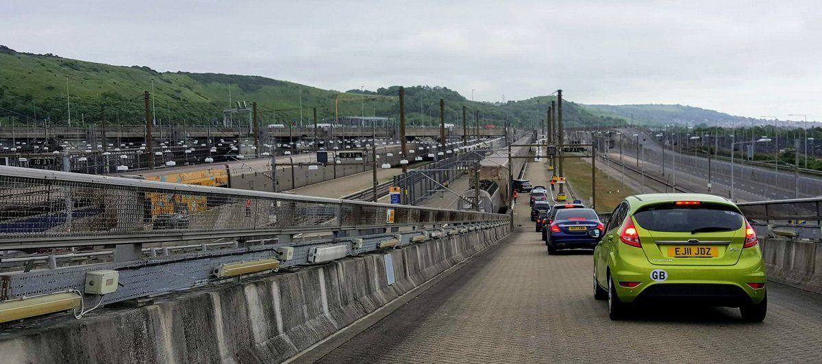 A line of cars driving down the ramp to a Eurotunnel Shuttle train