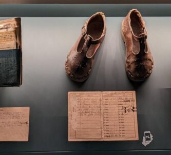 Display case of official documents needed by Parisians under occupation, and a pair of child's shoes