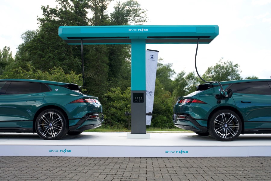 Two BYD DENZA cars under an electric charging stand