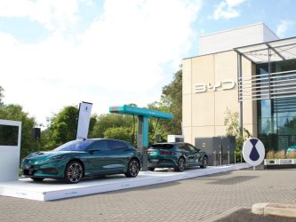 Two BYD cars under an electric charging stand