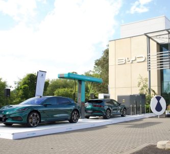 Two BYD cars under an electric charging stand