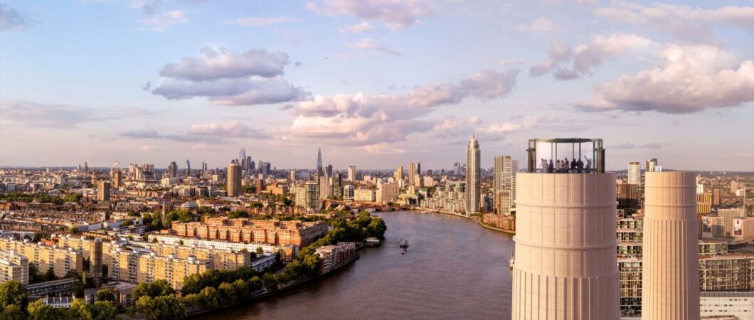 Aerial view of the glass Chimney Lift with people inside at the top of one of Battersea Power Station's chimneys. Behind an below is a panorama of the Thames and London on a glorious sunny day