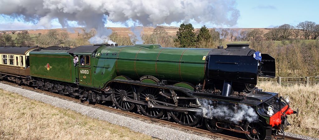 Flying Scotsman steaming along a track with the driver leaning out of the cab window