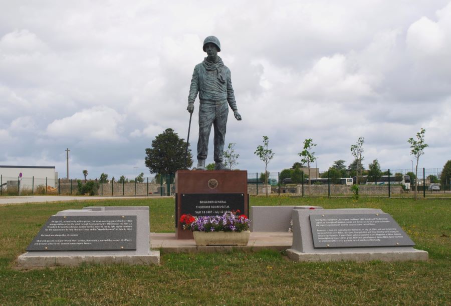 Lifesize statue on a plinth with memorial plaques around it