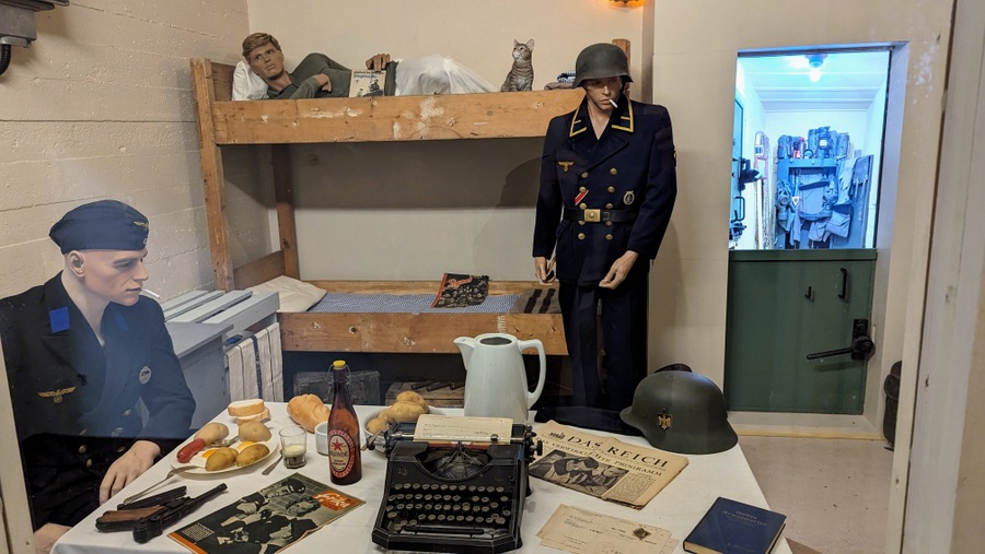 A guardroom in a bunker with soldiers lying on their bunk or sitting at a table