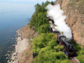 Luxury train with steam engine passing a lake