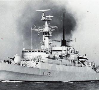 B&W photo of the destroyer, HMS Ambuscade, steaming out of a harbour