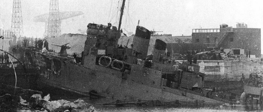 Black & white image of an old destroyer rammed into a dock gate