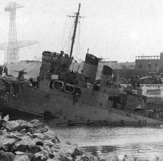 Black & white image of an old destroyer rammed into a dock gate