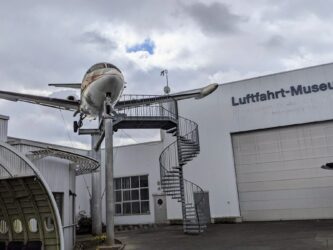 A small jet passenger plane sits on a gantry above the Hanover Aviation Museum