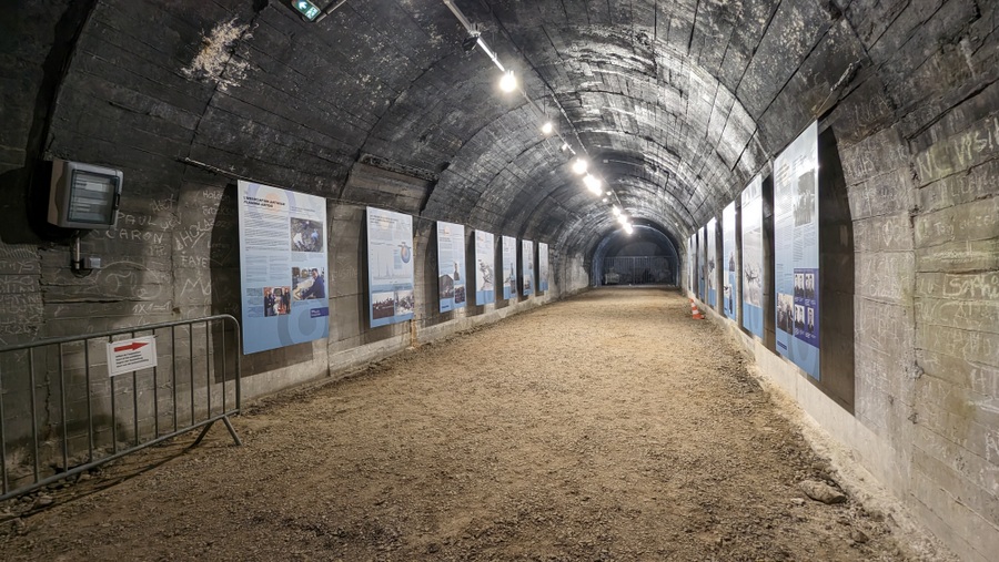 A brightly lit side tunnel with information panels down both walls