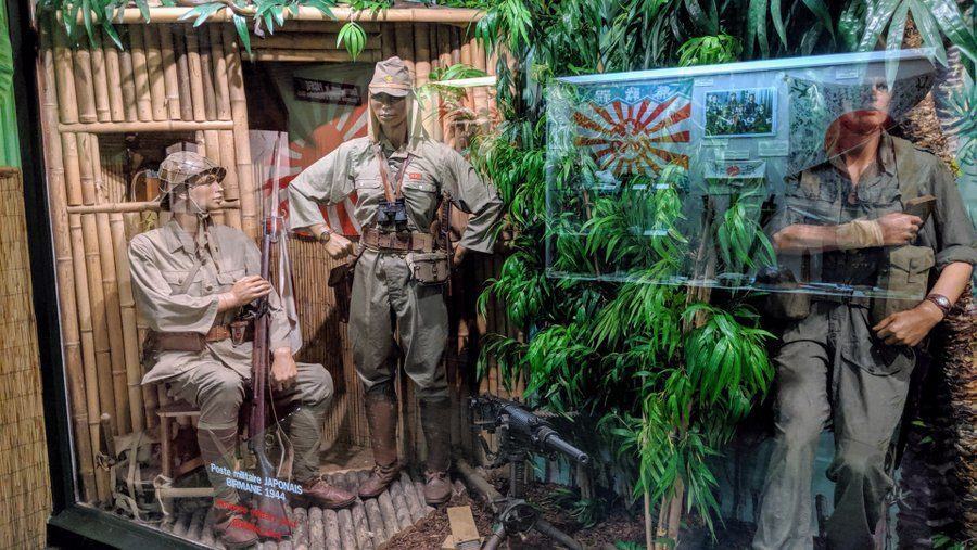 Japanese soldiers by a hut in a rainforest